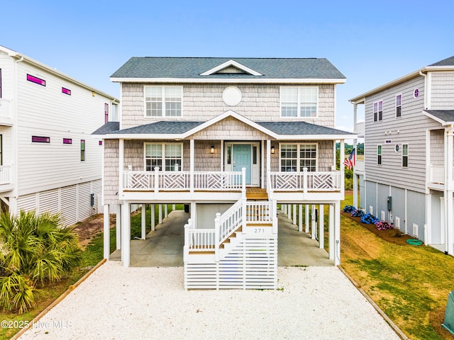 271 E Second St, Ocean Isle Beach, NC 28469 - coastal home featuring a carport, gravel driveway, covered porch, and roof with shingles