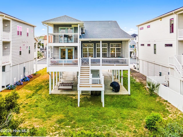 271 E Second St, Ocean Isle Beach, NC 28469 - rear view of house with a patio, a yard, a balcony, and roof with shingles