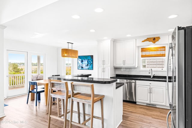 271 E Second St, Ocean Isle Beach, NC 28469 - kitchen featuring stainless steel appliances, plenty of natural light, white cabinetry, a kitchen breakfast bar, and recessed lighting