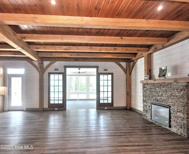 9265 W Lake Rd, Calabash, NC 28467 - unfurnished living room featuring wooden ceiling with exposed beams, plenty of natural light, dark wood finished floors, a ceiling fan, and a stone fireplace
