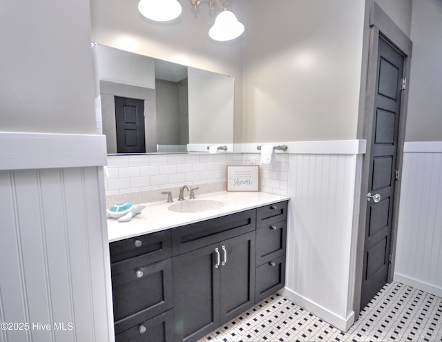 9265 W Lake Rd, Calabash, NC 28467 - bathroom with vanity, wainscoting, tile patterned flooring, and backsplash