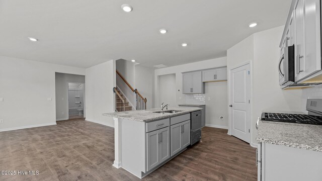 2023 Minnette Cir, New Bern, NC 28562 - kitchen featuring stainless steel appliances, a sink, a kitchen island with sink, decorative backsplash, and light stone countertops