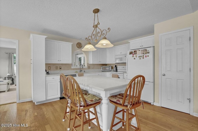 111 Bay Tree Cir, Hampstead, NC 28443 - kitchen with white appliances, light wood finished floors, white cabinets, and a textured ceiling
