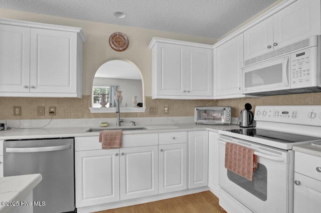 111 Bay Tree Cir, Hampstead, NC 28443 - kitchen featuring white appliances, a sink, light countertops, white cabinets, and tasteful backsplash