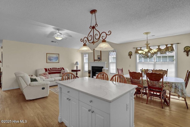 111 Bay Tree Cir, Hampstead, NC 28443 - kitchen featuring open floor plan, light wood-style flooring, a center island, a textured ceiling, and a chandelier
