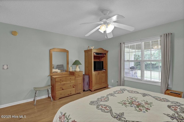 111 Bay Tree Cir, Hampstead, NC 28443 - bedroom with a textured ceiling, light wood-style flooring, a ceiling fan, and baseboards