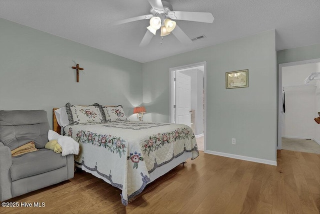 111 Bay Tree Cir, Hampstead, NC 28443 - bedroom featuring wood finished floors, baseboards, a ceiling fan, and a textured ceiling