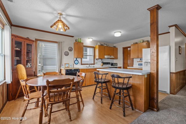 241 Moonlight Dr, Atlantic Beach, NC 28512 - dining room with a textured ceiling, light wood-style floors, plenty of natural light, and ornamental molding