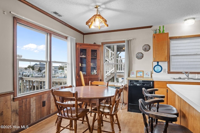 241 Moonlight Dr, Atlantic Beach, NC 28512 - dining area featuring light wood finished floors, a textured ceiling, and ornamental molding