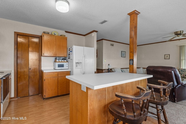 241 Moonlight Dr, Atlantic Beach, NC 28512 - kitchen featuring white appliances, brown cabinets, a ceiling fan, a textured ceiling, and light countertops