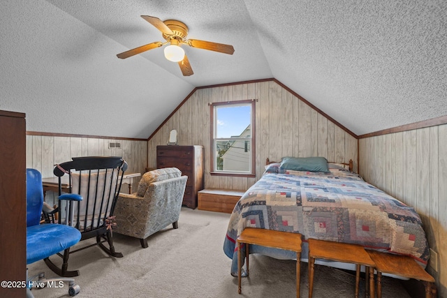 241 Moonlight Dr, Atlantic Beach, NC 28512 - bedroom with a textured ceiling, vaulted ceiling, carpet floors, wood walls, and a ceiling fan