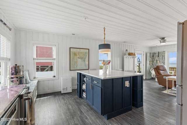 1001 W Beach Dr, Oak Island, NC 28465 - kitchen with blue cabinetry, healthy amount of natural light, and dark wood-style flooring
