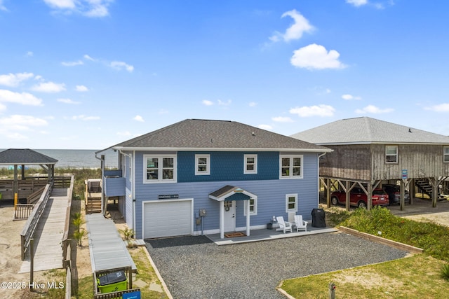 1001 W Beach Dr, Oak Island, NC 28465 - back of house with stairs, an attached garage, driveway, a gazebo, and a water view