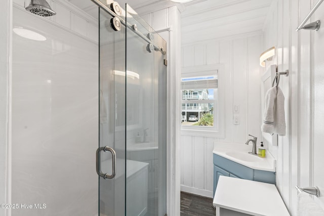 1001 W Beach Dr, Oak Island, NC 28465 - bathroom featuring a stall shower, vanity, ornamental molding, and a decorative wall