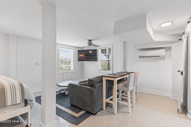 1001 W Beach Dr, Oak Island, NC 28465 - living area featuring a wall mounted air conditioner, baseboards, and ceiling fan
