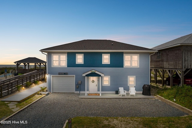 1001 W Beach Dr, Oak Island, NC 28465 - view of front of house featuring a gazebo, a garage, and gravel driveway