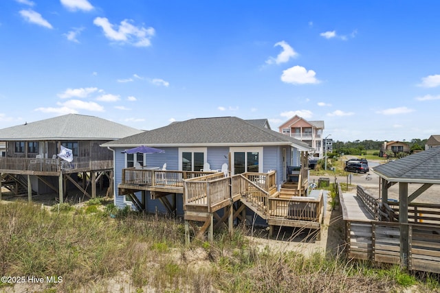 1001 W Beach Dr, Oak Island, NC 28465 - rear view of house with a wooden deck and a shingled roof