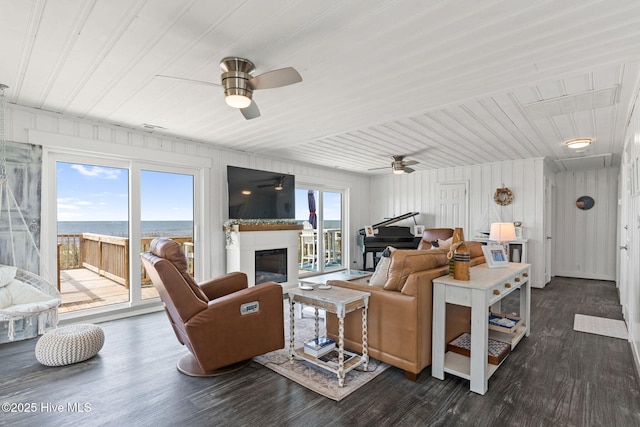 1001 W Beach Dr, Oak Island, NC 28465 - living area with a ceiling fan, dark wood finished floors, a glass covered fireplace, and wooden ceiling