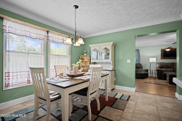 710 Ridgecrest Ln, Rocky Point, NC 28457 - dining space featuring crown molding, a chandelier, a textured ceiling, baseboards, and light tile patterned floors