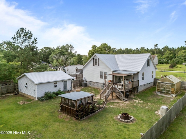 710 Ridgecrest Ln, Rocky Point, NC 28457 - back of property featuring a fire pit, a deck, stairway, a gazebo, and view of wooded area