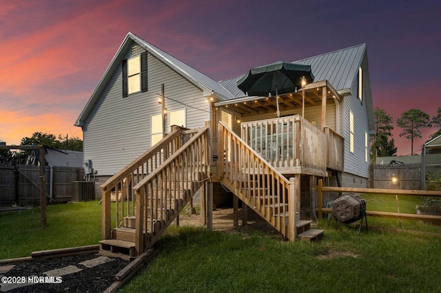 710 Ridgecrest Ln, Rocky Point, NC 28457 - back of house at dusk featuring a fenced backyard, stairway, a wooden deck, and a metal roof