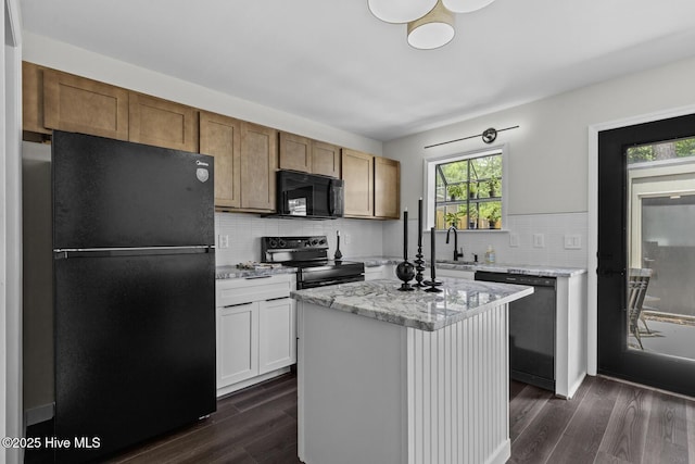 648 Cobblestone Dr, Wilmington, NC 28405 - kitchen featuring black appliances, dark wood-type flooring, tasteful backsplash, light stone counters, and a kitchen island
