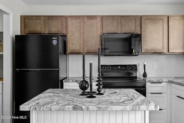 648 Cobblestone Dr, Wilmington, NC 28405 - kitchen featuring black appliances, tasteful backsplash, and light stone counters