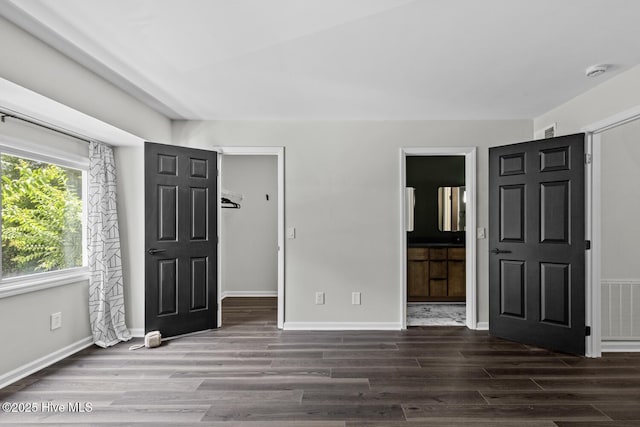648 Cobblestone Dr, Wilmington, NC 28405 - unfurnished bedroom featuring wood finished floors, baseboards, connected bathroom, and a spacious closet