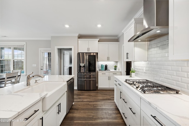 438 Sugar Cove Run, Wilmington, NC 28411 - kitchen featuring appliances with stainless steel finishes, wall chimney range hood, ornamental molding, white cabinetry, and dark wood-type flooring