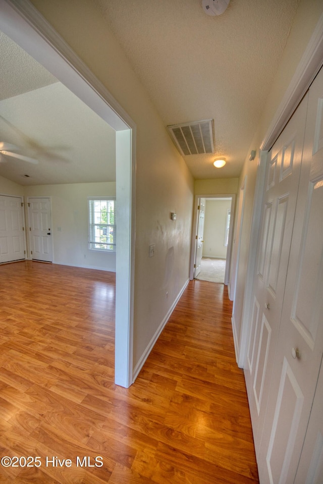 7308 Peppercorn Ct, Wilmington, NC 28411 - corridor with light wood-style floors, baseboards, and a textured ceiling