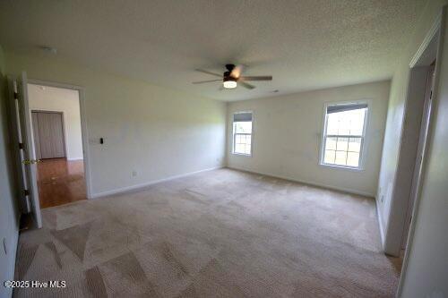 7308 Peppercorn Ct, Wilmington, NC 28411 - empty room featuring light colored carpet, a ceiling fan, and baseboards