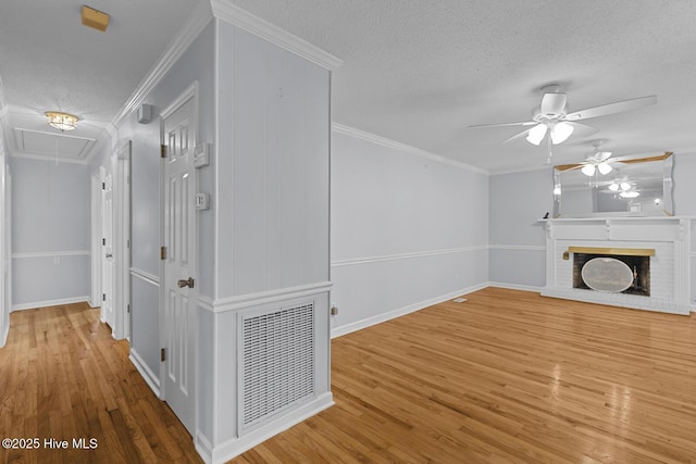 1205 Logan Ct, Jacksonville, NC 28540 - unfurnished living room with attic access, a ceiling fan, wood finished floors, a fireplace, and a textured ceiling