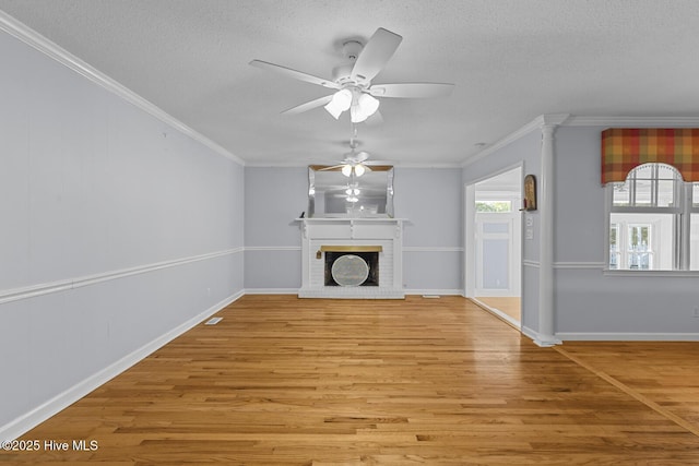 1205 Logan Ct, Jacksonville, NC 28540 - unfurnished living room featuring a ceiling fan, wood finished floors, ornamental molding, a textured ceiling, and a brick fireplace