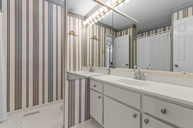 1205 Logan Ct, Jacksonville, NC 28540 - bathroom with wallpapered walls, a textured ceiling, and vanity