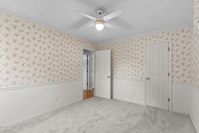 1205 Logan Ct, Jacksonville, NC 28540 - unfurnished bedroom with wallpapered walls, wainscoting, ornamental molding, carpet, and ceiling fan