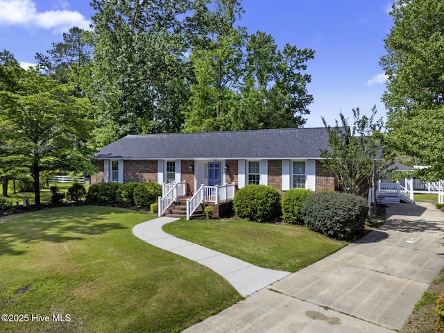 1205 Logan Ct, Jacksonville, NC 28540 - single story home with brick siding, a front yard, driveway, and roof with shingles