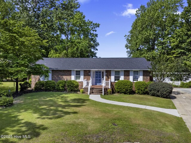 1205 Logan Ct, Jacksonville, NC 28540 - ranch-style home featuring brick siding, a front lawn, and roof with shingles