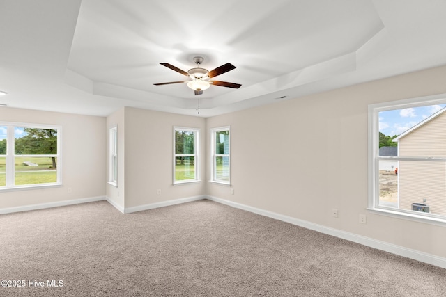 411 Fore Pl, Jacksonville, NC 28540 - empty room featuring a tray ceiling, ceiling fan, plenty of natural light, and light colored carpet