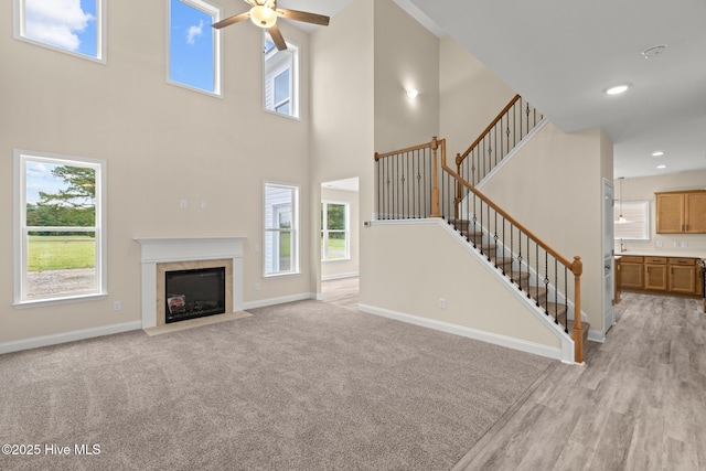 411 Fore Pl, Jacksonville, NC 28540 - unfurnished living room with ceiling fan, baseboards, a high ceiling, healthy amount of natural light, and a tile fireplace