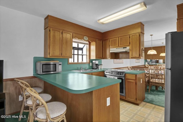 308 N Shore Dr E, Sunset Beach, NC 28468 - kitchen with appliances with stainless steel finishes, under cabinet range hood, a peninsula, a sink, and light flooring