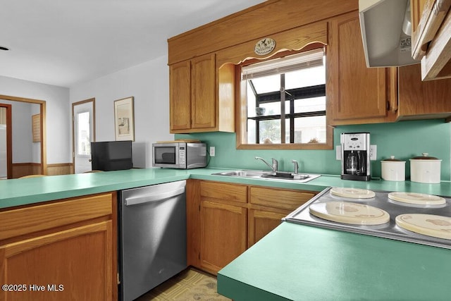 308 N Shore Dr E, Sunset Beach, NC 28468 - kitchen featuring appliances with stainless steel finishes, a sink, light countertops, ventilation hood, and brown cabinetry