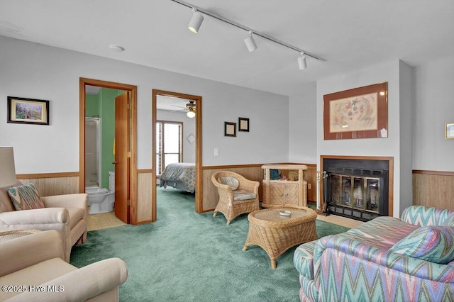 308 N Shore Dr E, Sunset Beach, NC 28468 - living room featuring a wainscoted wall, track lighting, carpet flooring, wood walls, and a ceiling fan