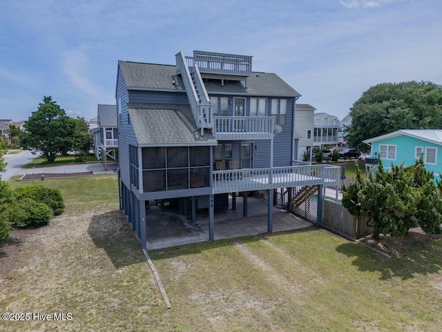 308 N Shore Dr E, Sunset Beach, NC 28468 - back of house featuring a shingled roof, a sunroom, a lawn, stairs, and a wooden deck