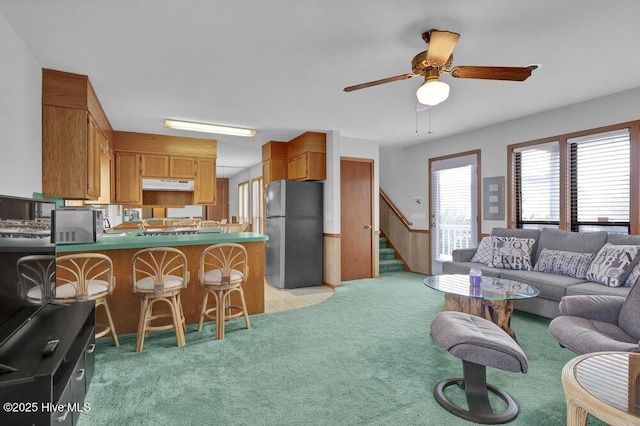 308 N Shore Dr E, Sunset Beach, NC 28468 - living room with light carpet, stairs, and ceiling fan