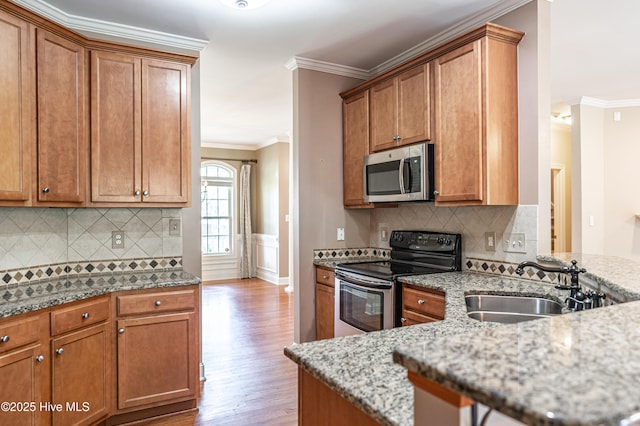 600 Booth Pond Rd, Raeford, NC 28376 - kitchen with stainless steel microwave, range with electric stovetop, a sink, wood finished floors, and ornamental molding
