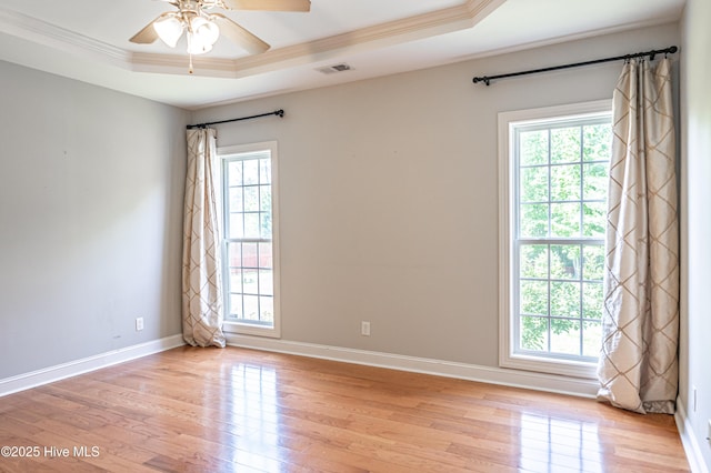 600 Booth Pond Rd, Raeford, NC 28376 - unfurnished room with a tray ceiling, crown molding, healthy amount of natural light, light wood finished floors, and a ceiling fan