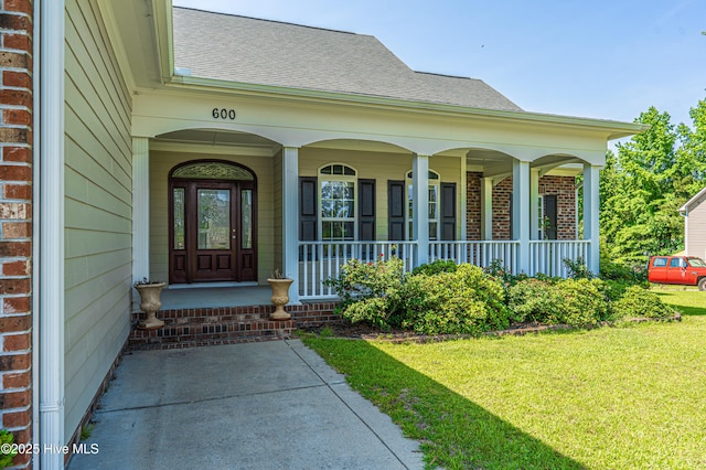 600 Booth Pond Rd, Raeford, NC 28376 - entrance to property featuring a shingled roof, a lawn, brick siding, and a porch