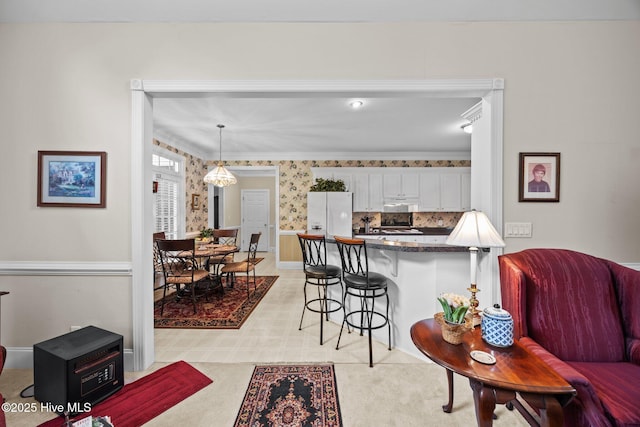 2995 H C Turner Rd, Pink Hill, NC 28572 - kitchen with freestanding refrigerator, a breakfast bar, a peninsula, white cabinets, and crown molding