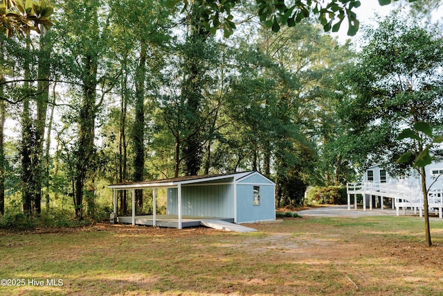 1498 Bayview Rd, Bath, NC 27808 - view of grassy yard featuring an outbuilding, a carport, and view of wooded area