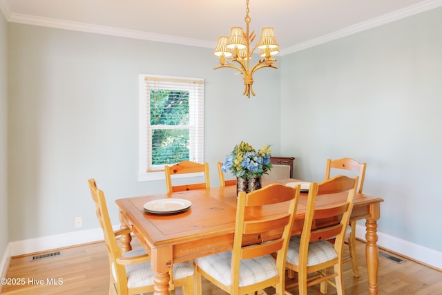 1498 Bayview Rd, Bath, NC 27808 - dining space featuring a chandelier, light wood-type flooring, crown molding, and baseboards